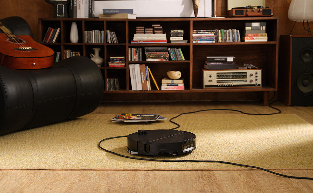 Saros 10 robot vacuum and dock in a room setting.